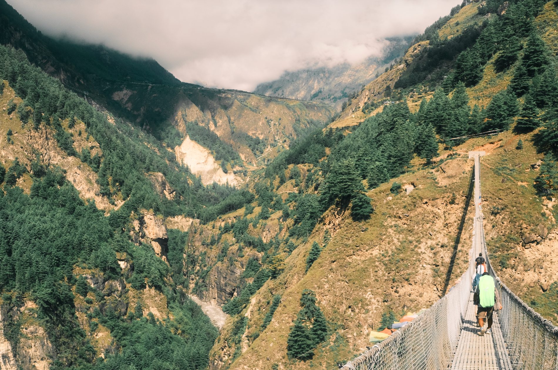 Trekkers crossing a suspension bridge in the Nepal Himalaya